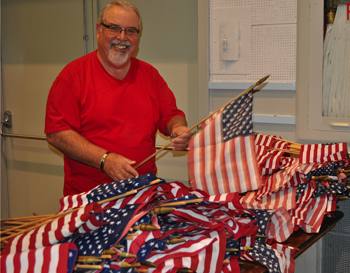 Ray Dorfman prepares flags for decorations